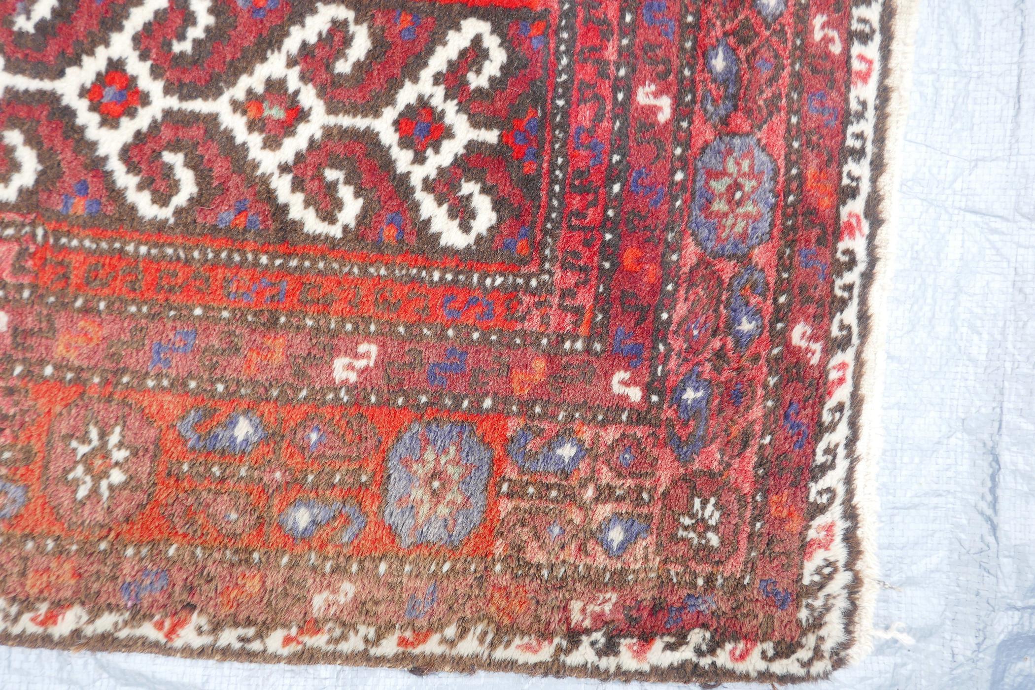 A Middle Eastern full pile red ground wool rug with a three panel geometric design, 34" x 56" - Image 3 of 4