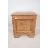 A walnut Art Deco side cabinet with a carved panel door and ribbed feet, 25½" x 16", 28" high