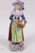 A Dresden porcelain figure of a girl selling oranges, 7" high