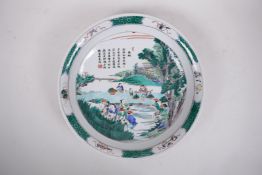 A Chinese famille verte porcelain charger decorated with a rural landscape depicting rice paddy