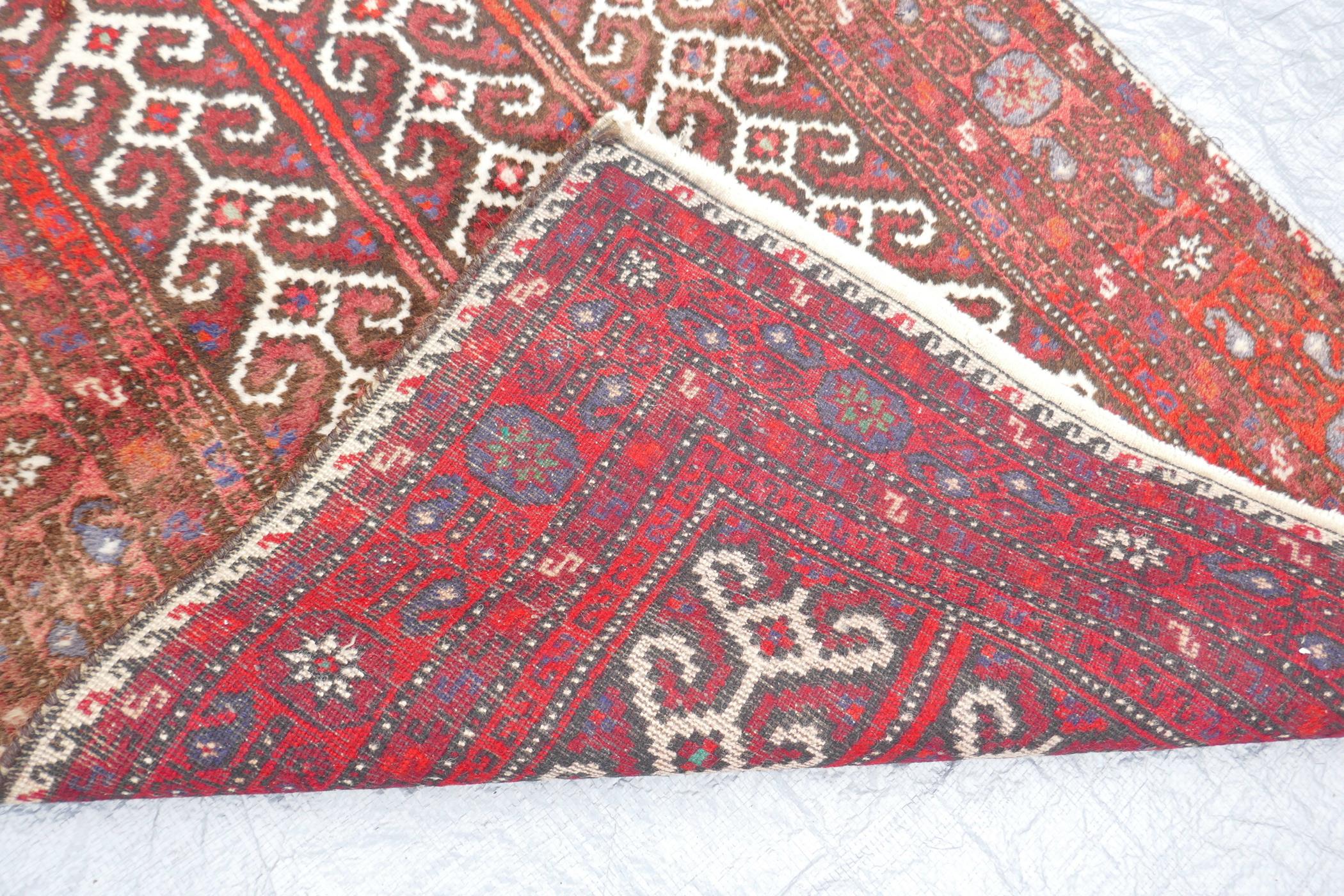 A Middle Eastern full pile red ground wool rug with a three panel geometric design, 34" x 56" - Image 4 of 4