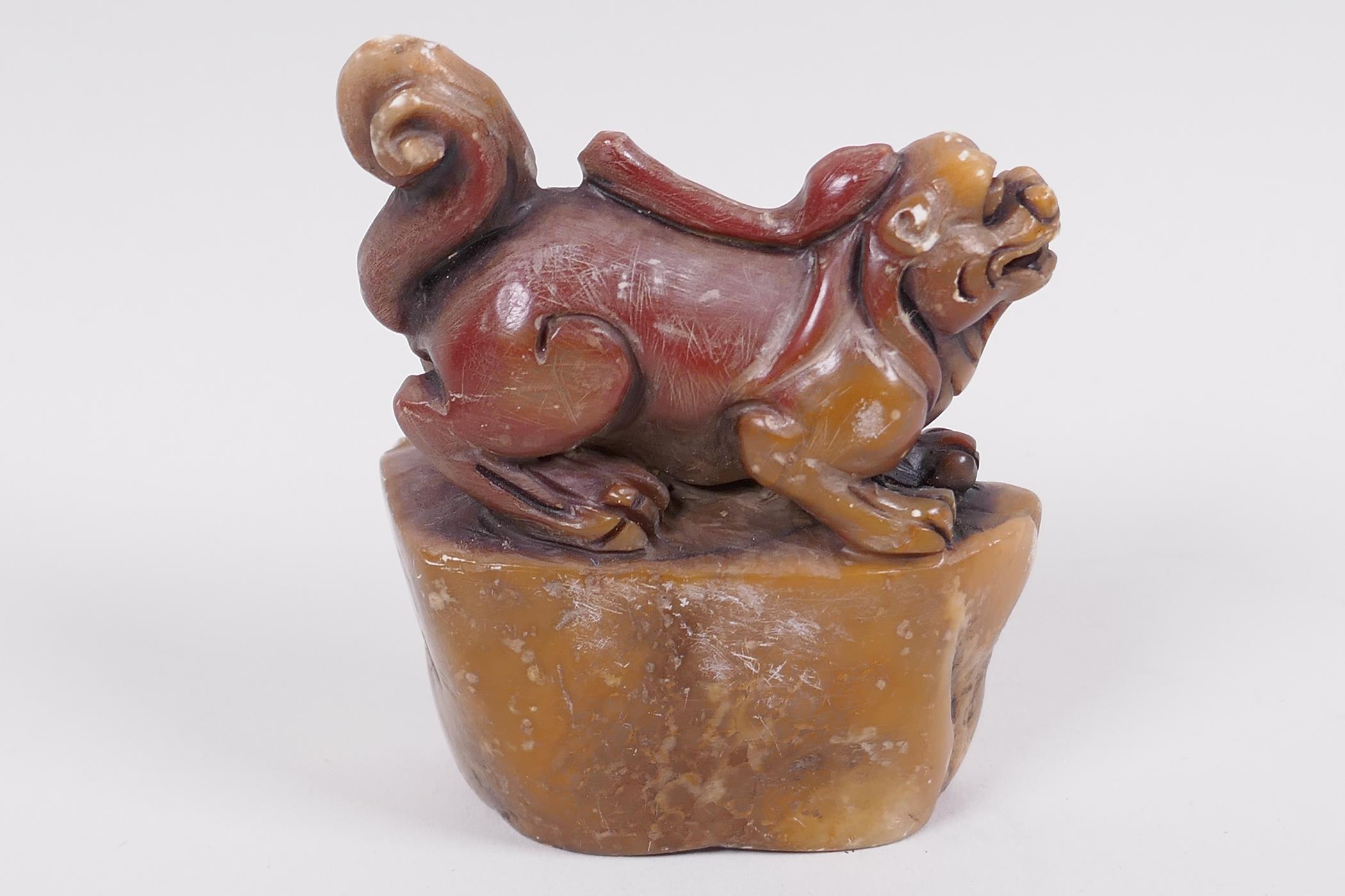 A Chinese carved soapstone seal, the top carved as a kylin on a shaped rock, 3" high - Image 2 of 3