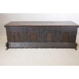 An C18th Italian oak cassone, with carved frieze and four arched panel front, initialled and dated
