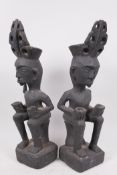 A pair of Indonesian tribal carved wood seated figures, 13" high