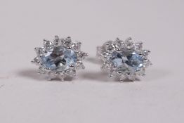 A pair of 18ct white gold, aquamarine and diamond cluster earrings, approximately 1.3cts