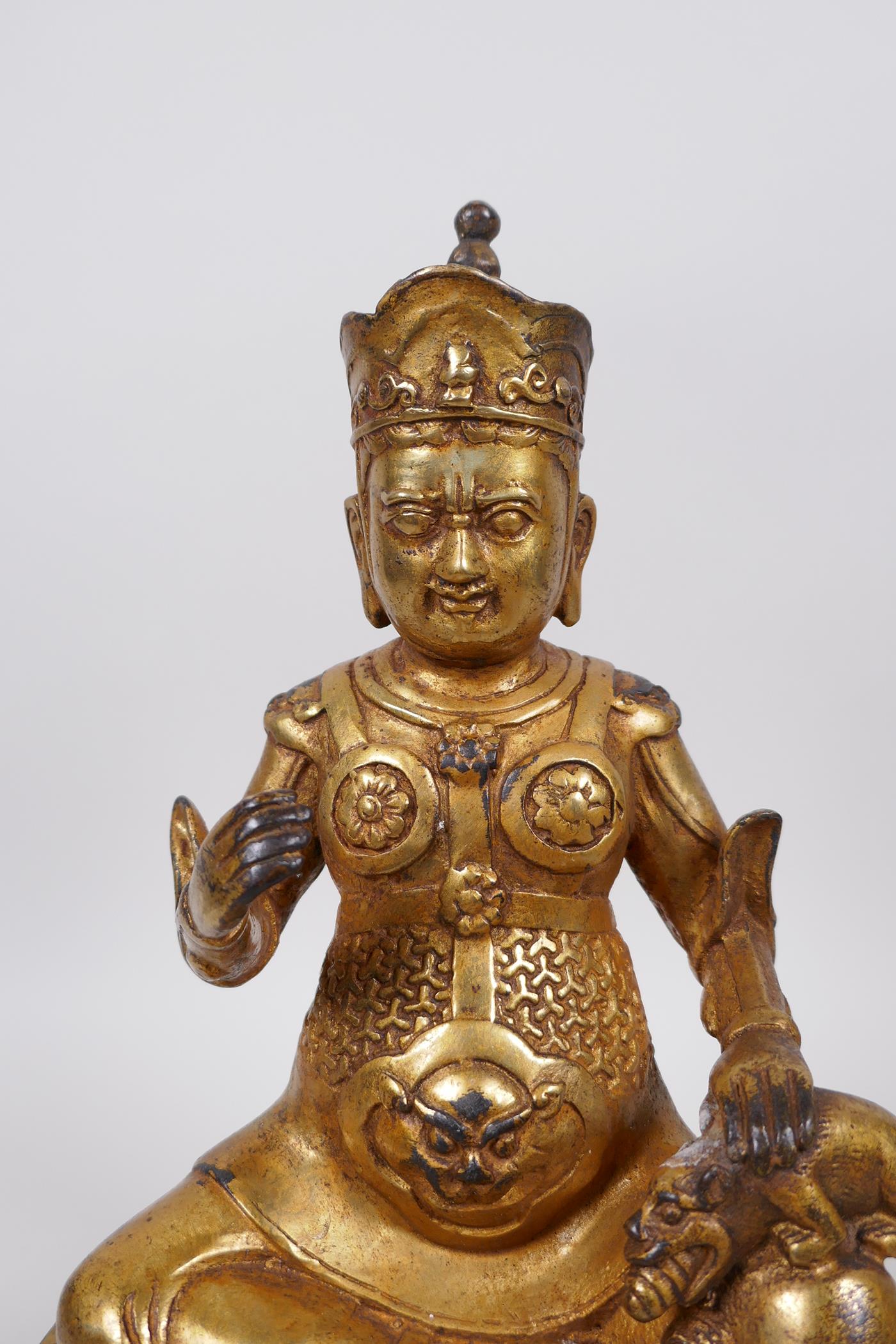A Tibetan gilt bronze of a deity seated on a lotus throne accompanied by a rat, 10" high - Image 2 of 4