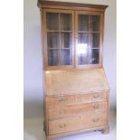 A late Victorian oak fall front bureau bookcase, with glazed upper section, fitted fall and three