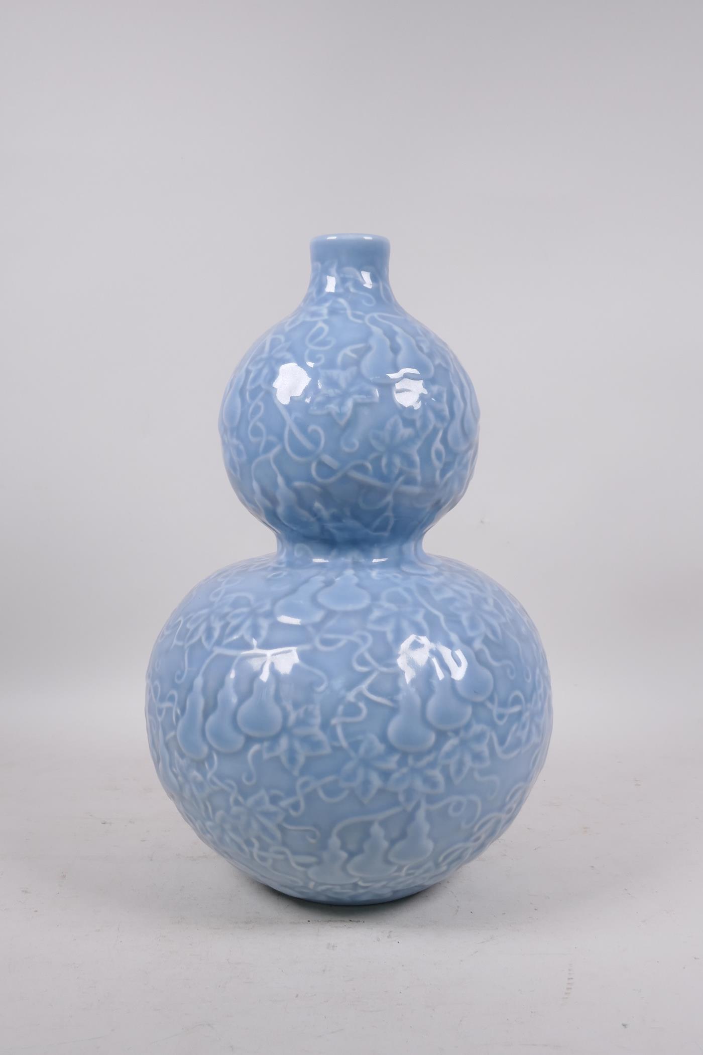 A Chinese light blue glazed porcelain double gourd vase with raised all over gourd vine - Image 2 of 5