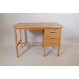 A light oak utilitarian three drawer desk with a stationary slide, 42" x 24", 30" high