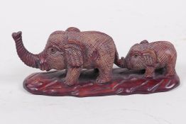 A Japanese carved wood okimono figure of two elephants (signed), 4½" long