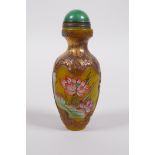 A Chinese Peking glass snuff bottle with enamelled and gilt lotus flower decoration, character