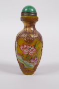 A Chinese Peking glass snuff bottle with enamelled and gilt lotus flower decoration, character