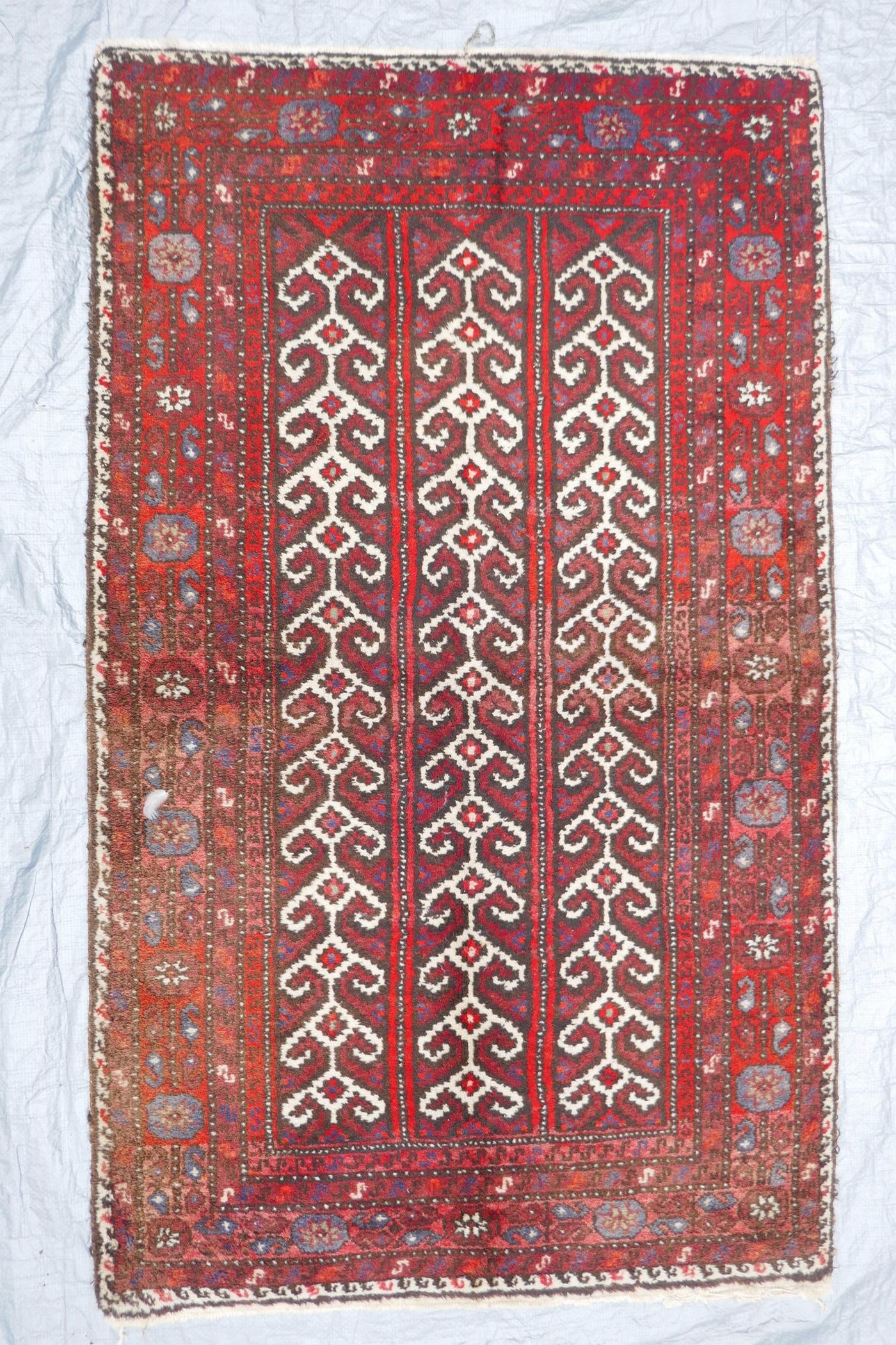 A Middle Eastern full pile red ground wool rug with a three panel geometric design, 34" x 56" - Image 2 of 4