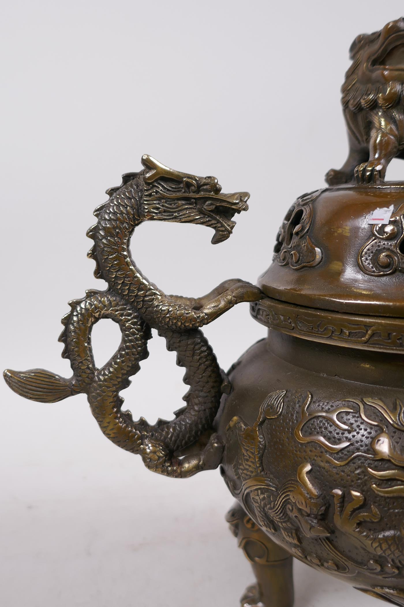 A Bronze Chinese dragon censer and cover with two handles and a fo dog knop, raised on tripod - Image 3 of 6