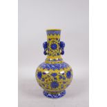 A Chinese yellow ground porcelain vase with two elephant mask handles and blue and white lotus
