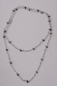 A white gold necklace set with seed pearls and faceted sapphire spacers, 19" long, marked 750 to