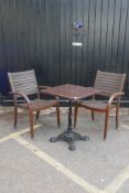 Two teak garden elbow chairs and a table with cast iron base and composite top, 23" x 23", 29" high