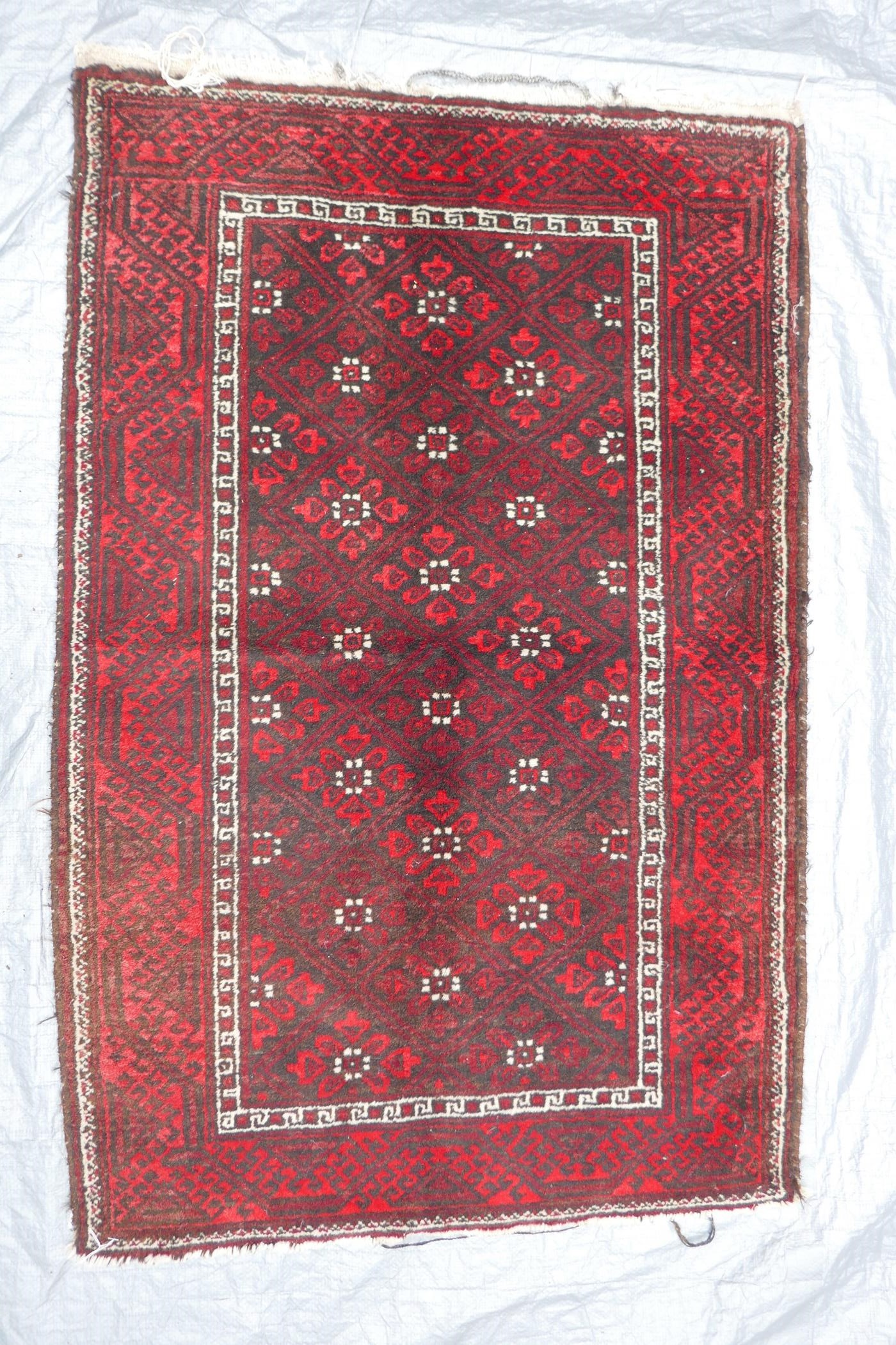 A Middle Eastern red ground wool rug with a repeating diamond pattern design, 34" x 51" - Image 2 of 6