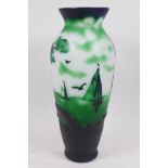 An overlaid green glass vase with decoration of sailing boats off the coast, in the style of