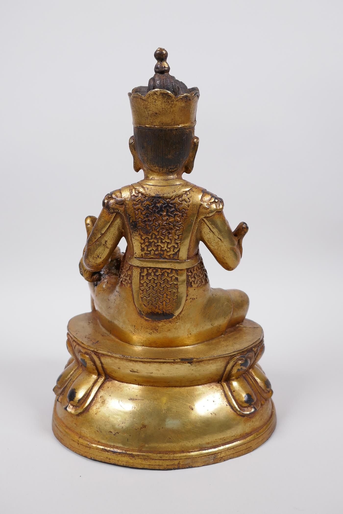 A Tibetan gilt bronze of a deity seated on a lotus throne accompanied by a rat, 10" high - Image 3 of 4