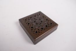 A sino Tibetan bronze incense box and pierced cover, decorated with auspicious symbols, impressed