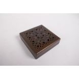 A sino Tibetan bronze incense box and pierced cover, decorated with auspicious symbols, impressed