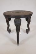 An Indian rosewood table with finely carved top, raised on three detachable supports in the form