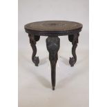 An Indian rosewood table with finely carved top, raised on three detachable supports in the form