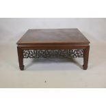 A Chinese low table, with pierced frieze, raised on square supports with spade feet, 41" x 41" x 18"