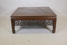 A Chinese low table, with pierced frieze, raised on square supports with spade feet, 41" x 41" x 18"