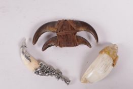 A leather bound animal claw pendant and two animal tooth pendants, largest 3" wide
