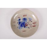 A Chinese crackle ware dish with blue, white and red temple lion decoration, 10" diameter