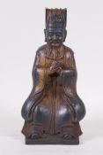 A Chinese gilt brass figure of a nobleman, seated with hands clasped, seal mark verso, 9" high