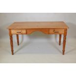 A pine two drawer writing table with two frieze drawers on turned supports, 30" high, 59" wide,