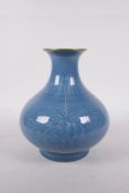 A Chinese light blue glazed porcelain vase with a gilt rim and underglaze decoration of branches
