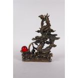 A Chinese filled bronze figure of a dragon chasing a red glass flaming earl, seal mark to base, 7"