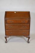 An Edwardian fall front bureau with three drawers, the interior fitted with pigeon holes, raised