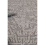 A silk and wool deep pile carpet with repeating geometric design, silver grey on an off white field,