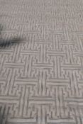 A silk and wool deep pile carpet with repeating geometric design, silver grey on an off white field,