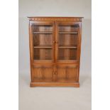 An Ercol two door glazed display cabinet over two cupboard doors on a plinth base, 54" high, 40"