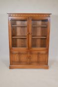 An Ercol two door glazed display cabinet over two cupboard doors on a plinth base, 54" high, 40"