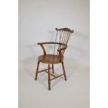 A C19th comb back beech and birchwood elbow chair, with scroll end arms, raised on turned supports