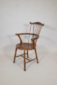 A C19th comb back beech and birchwood elbow chair, with scroll end arms, raised on turned supports