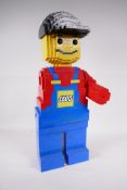 A Lego figure of a man made from regular sized Lego bricks, one arm missing, 20" high