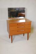 A mid century teak veneered dressing table of small proportions with three long drawers, 29" x