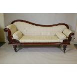 An early C19th mahogany settee/daybed with shaped back, carved scroll arms and moulded frame, raised