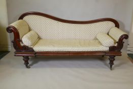 An early C19th mahogany settee/daybed with shaped back, carved scroll arms and moulded frame, raised