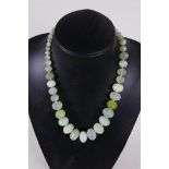 A graduated string of faceted green jade beads, 20" long