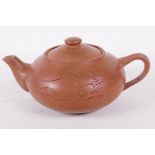 A Chinese Yixing pottery teapot engraved with a mountain landscape, 7" long