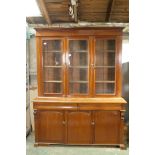 A C19th cabinet bookcase, the upper section with three glazed doors and fitted shelves, over a two
